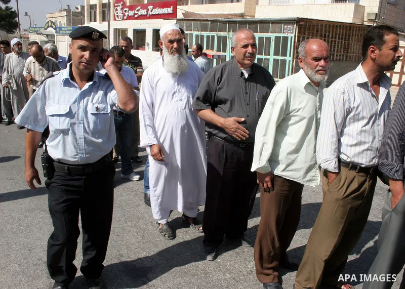 Palestinian men walk into 'separation barrier' or wall where slightly opened at the Israeli checkpoint in Bethlehem, as Palestinians cross from the West Bank Bank into Jerusalem on Aug. 5, 2011 in order to attend the Fir...