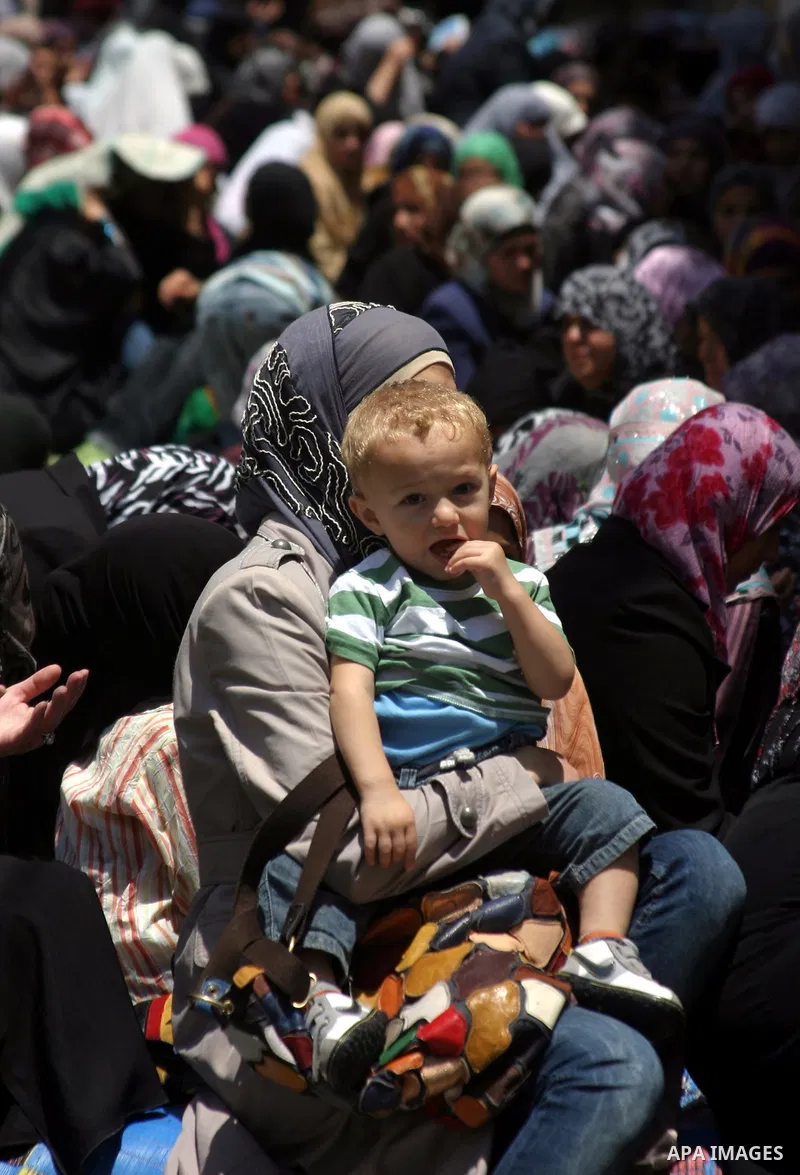 Israeli soldiers (not seen) stand guard as the Palestinian women perform the first Friday prayer of the holy Muslim month of Ramadan in front of the closed Ibrahimi mosque in the West Bank city of Hebron, August 05 2011....