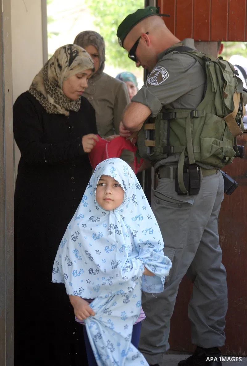 A Palestinian woman is being checked at an Israeli army checkpoint on her way to pray in the Ibrahimi Mosque in the West Bank city of Hebron, on Aug. 5, 2011. Muslims throughout the world are marking the month of Ramadan...