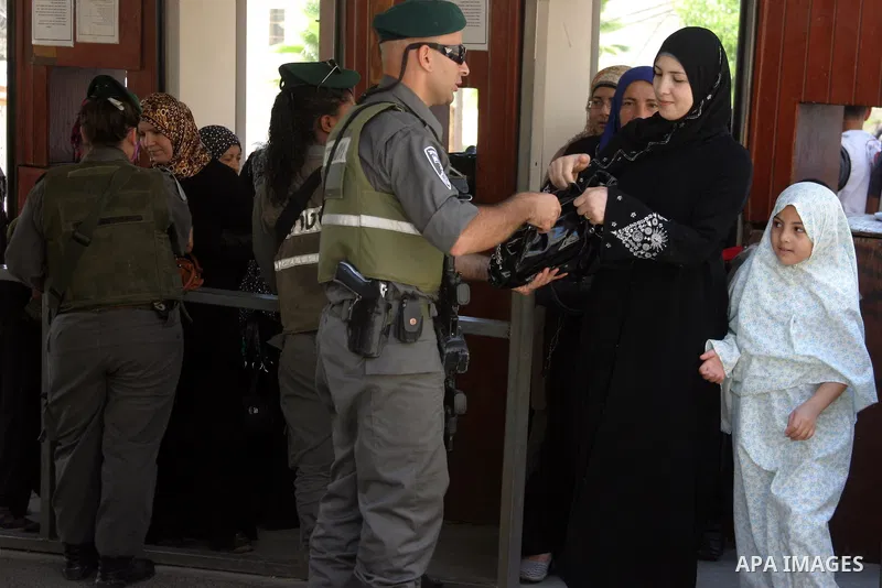 A Palestinian woman is being checked at an Israeli army checkpoint on her way to pray in the Ibrahimi Mosque in the West Bank city of Hebron, on Aug. 5, 2011. Muslims throughout the world are marking the month of Ramadan...
