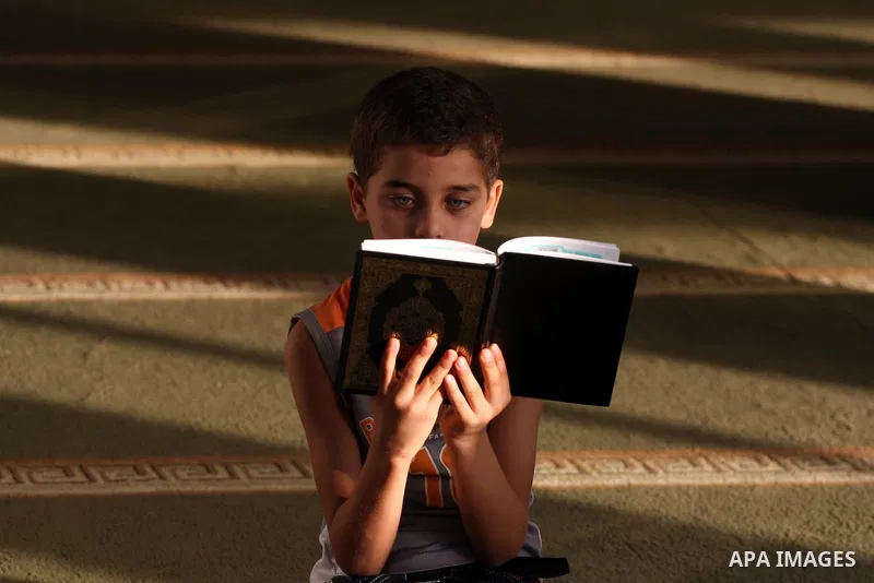 A Palestinian boy reads the holy Koran at the Big Mosque in the West Bank town of Ramallah, during the Muslim holy fasting month of Ramadan, on Aug. 6, 2011. Muslims throughout the world are celebrating the holy fasting...