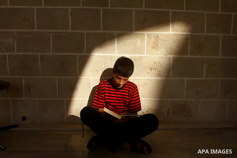 A Palestinian boy reads the holy Koran at al-Omari Mosque in Gaza city, during the Muslim holy fasting month of Ramadan, on Aug. 6, 2011. Muslims throughout the world are celebrating the holy fasting month of Ramadan, th...