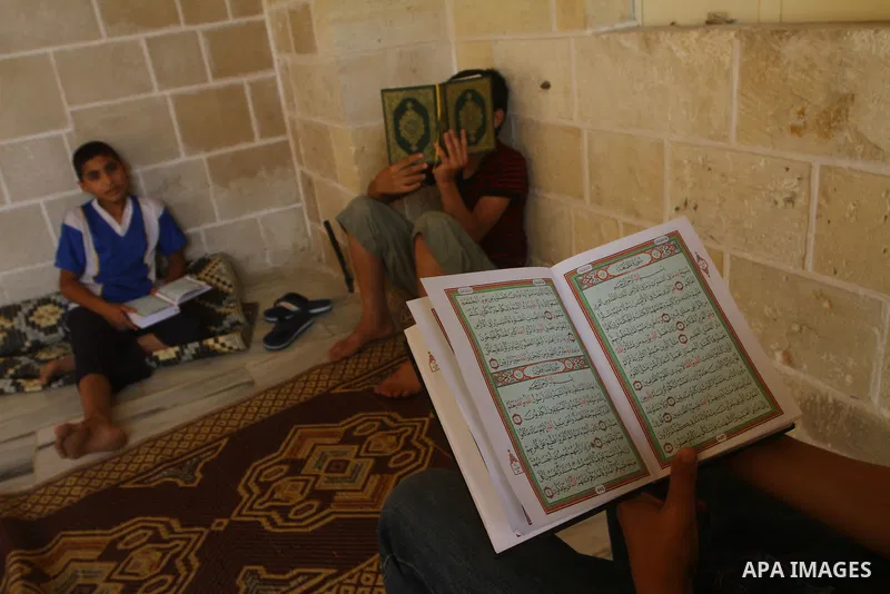 Palestinian boys read the holy Koran at al-Omari Mosque in Gaza city, during the Muslim holy fasting month of Ramadan, on Aug. 6, 2011. Muslims throughout the world are celebrating the holy fasting month of Ramadan, the...