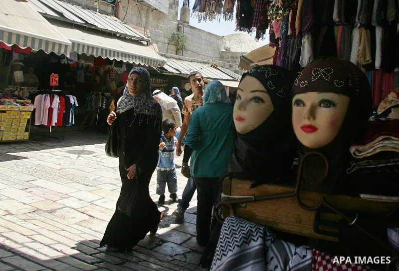 Israeli border guard (unseen) keep watch Palestinians as they shop at a market, in the old city of Jerusalem on Aug. 8, 2011. Muslims throughout the world are marking the month of Ramadan, during which they refrain from...