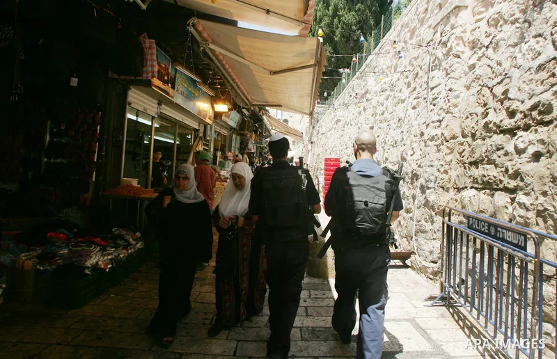 Israeli border guard keep watch Palestinians as they shop at a market, in the old city of Jerusalem on Aug. 8, 2011. Muslims throughout the world are marking the month of Ramadan, during which they refrain from eating, d...