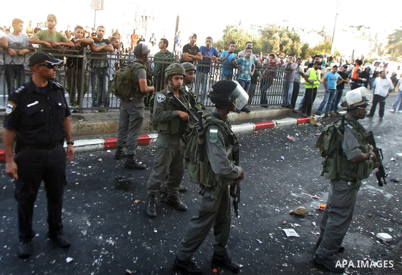 Israeli border guard keep watch Palestinians as they shop at a market, in the old city of Jerusalem on Aug. 8, 2011. Muslims throughout the world are marking the month of Ramadan, during which they refrain from eating, d...