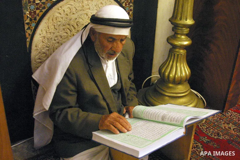 A Palestinian man reads the holy Koran at the Ibrahimi Mosque in the West Bank city of Hebron,on Aug. 8, 2011. Muslims around the world are observing the fasting month of Ramadan during which they refrain from eating, dr...