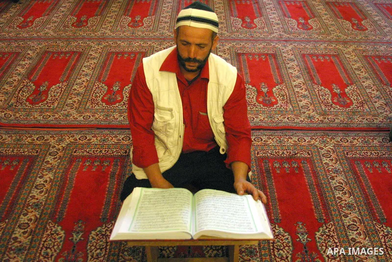 A Palestinian man reads the holy Koran at the Ibrahimi Mosque in the West Bank city of Hebron,on Aug. 8, 2011. Muslims around the world are observing the fasting month of Ramadan during which they refrain from eating, dr...