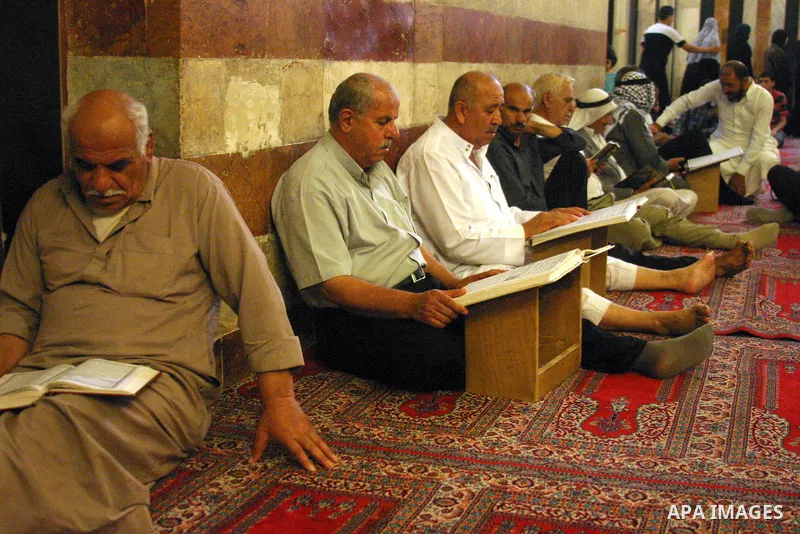 Palestinian men read the holy Koran at the Ibrahimi Mosque in the West Bank city of Hebron,on Aug. 8, 2011. Muslims around the world are observing the fasting month of Ramadan during which they refrain from eating, drink...