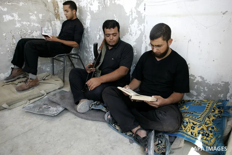Palestinian Hamas policemen read the holy Koran near the tunnels between Egypt and Gaza border in Rafah, southern Gaza Strip on Aug. 8, 2011. Muslims around the world refrain from eating, drinking and sexual intercourse...