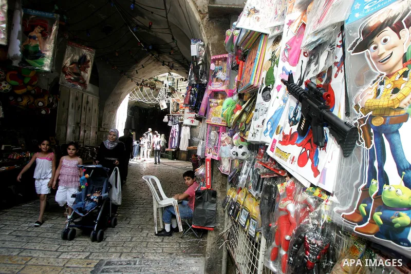 Palestinians are seen silhouetted at the entrance of the brightly lit Al-Aqsa mosque compound, in the old city of Jerusalem, during the holy month of Ramadan. 8 August 2011. Photo by Mahfouz Abu Turk