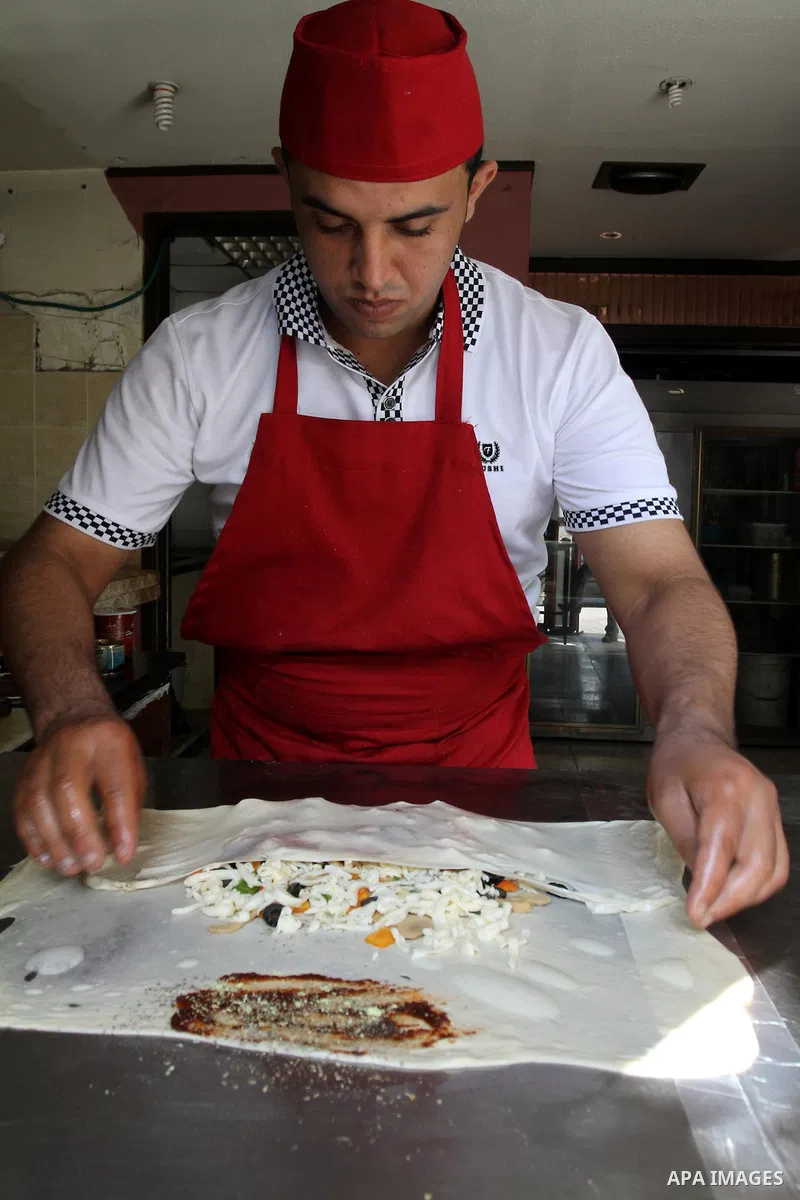 A Palestinian chef prepares Pastry or "Fatayer" with municipal ghee on a new forms at Colonel restaurant in Gaza city on Aug. 9, 2011, where prepare many forms such as pastry pizza, apple pie and pastry pillow. Muslims a...