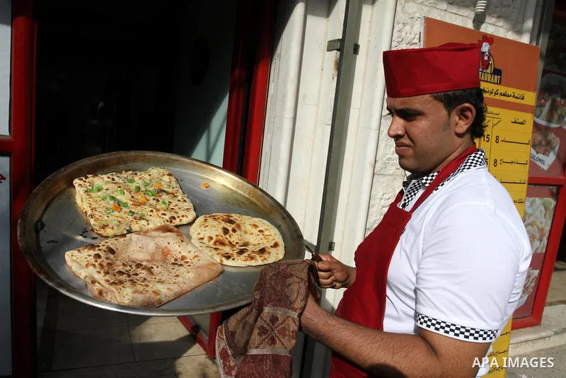 A Palestinian chef prepares Pastry or "Fatayer" with municipal ghee on a new forms at Colonel restaurant in Gaza city on Aug. 9, 2011, where prepare many forms such as pastry pizza, apple pie and pastry pillow. Muslims a...