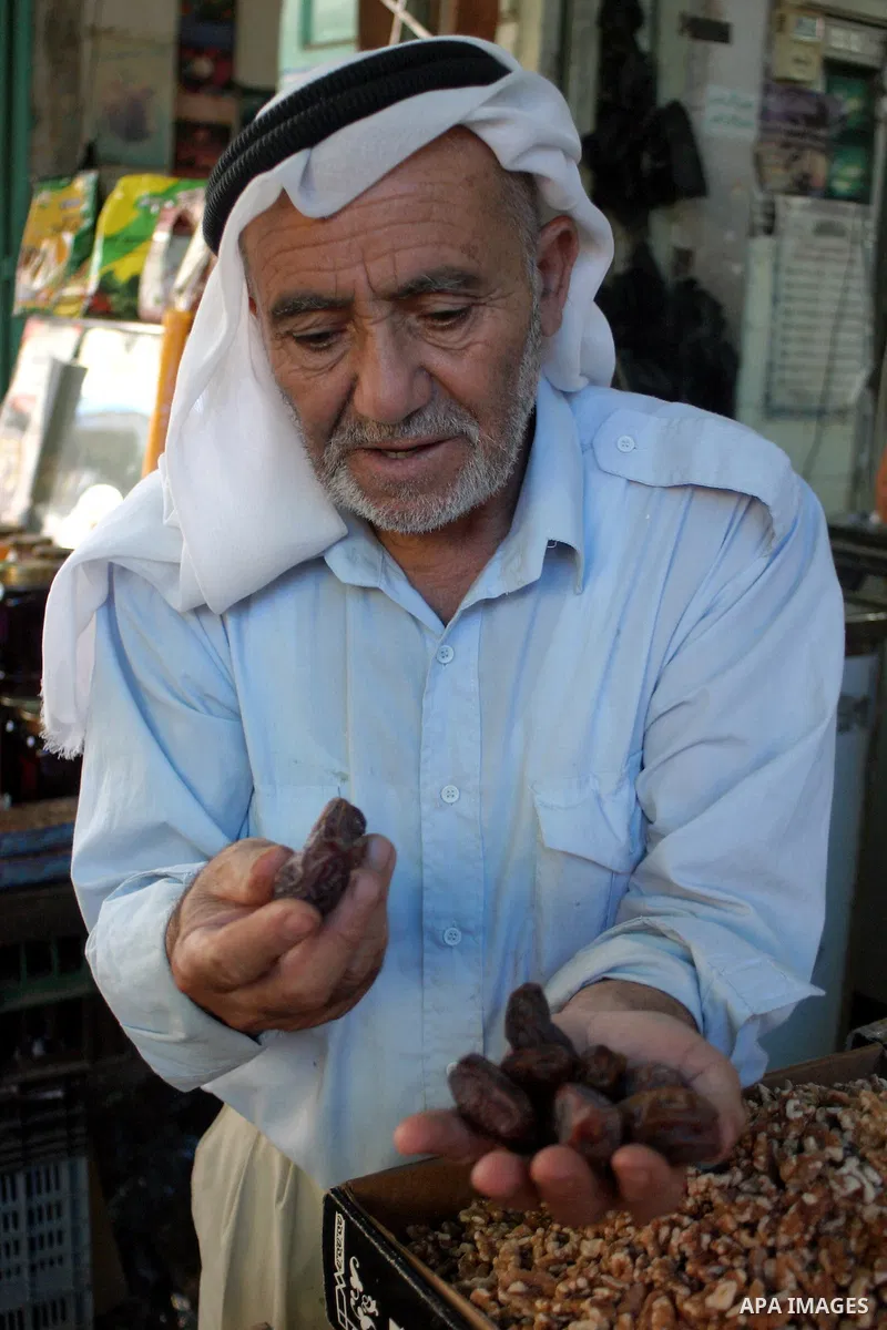 A Palestinian vendor sells dates in his shop in the West Bank city of Hebron Aug. 9, 2011. Muslims around the world abstain from eating, drinking and conducting sexual relations from sunrise to sunset during Ramadan, the...