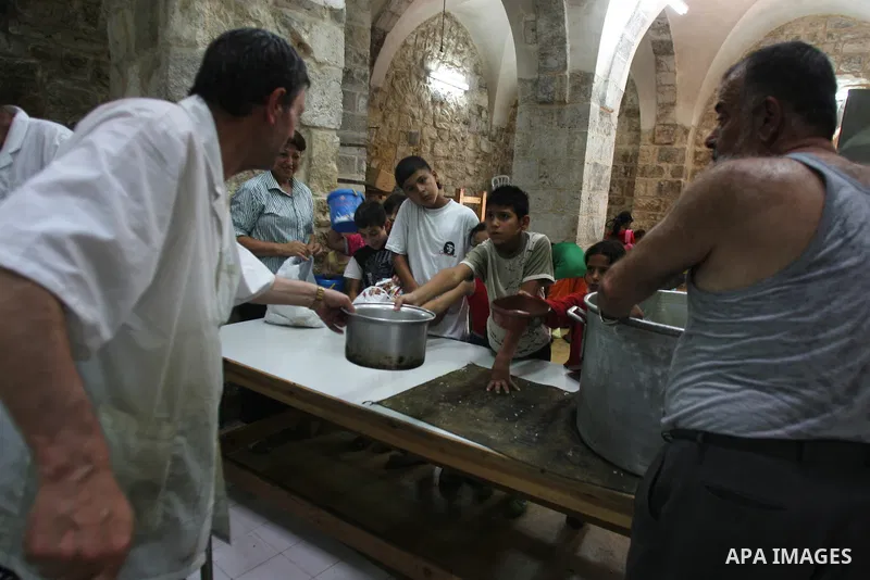 Palestinian children receive food rations on August 9,2011 distributed by the Waqf, a Jordanian-backed body that oversees Muslim holy sites in Jerusalem, on the second week of the fasting month of Ramadan in Jerusalem's...