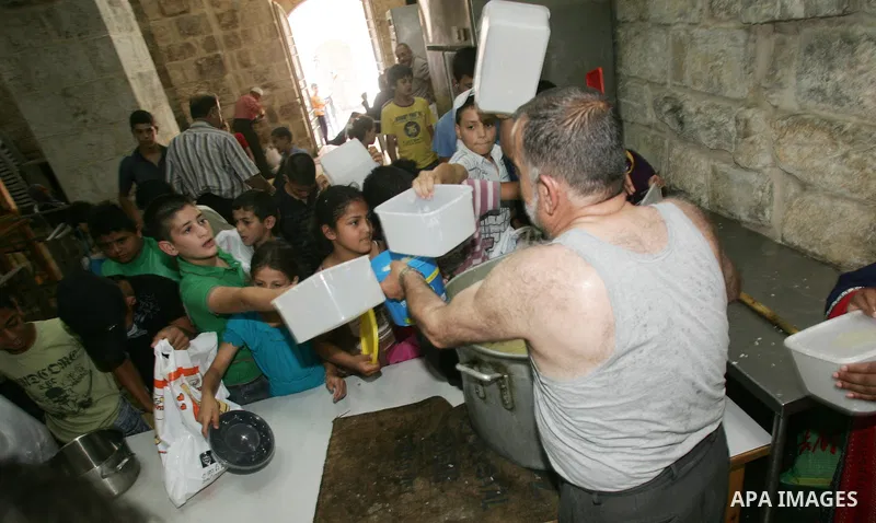 Palestinian children receive food rations on August 9,2011 distributed by the Waqf, a Jordanian-backed body that oversees Muslim holy sites in Jerusalem, on the second week of the fasting month of Ramadan in Jerusalem's...