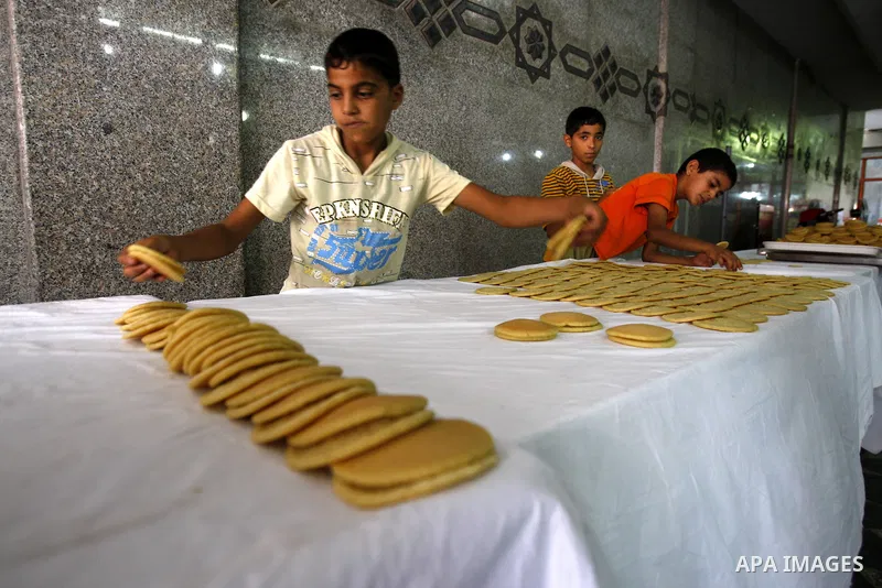 Palestinian boys prepare qatayef, a popular sweet to sell it during Ramadan, at a shop in Gaza city on Aug.10, 2011. Muslims around the world are observing the holy fasting month of Ramadan where they refrain from eating...