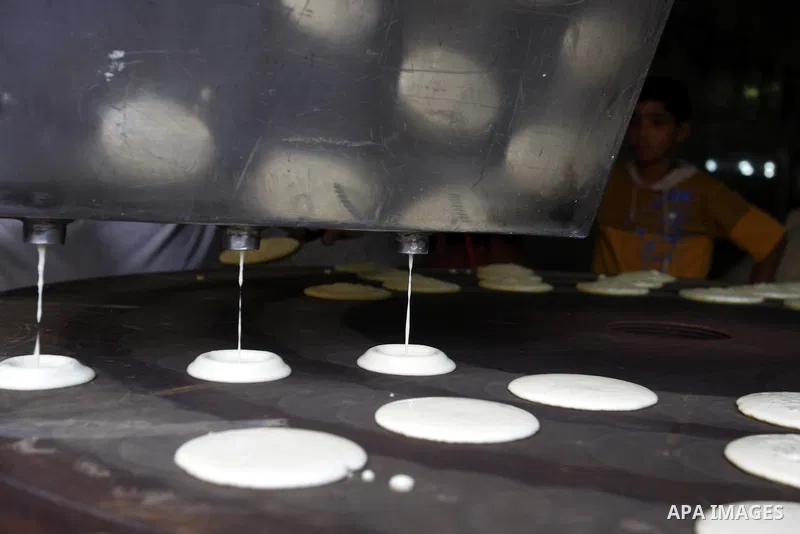 Palestinian boys prepare qatayef, a popular sweet to sell it during Ramadan, at a shop in Gaza city on Aug.10, 2011. Muslims around the world are observing the holy fasting month of Ramadan where they refrain from eating...