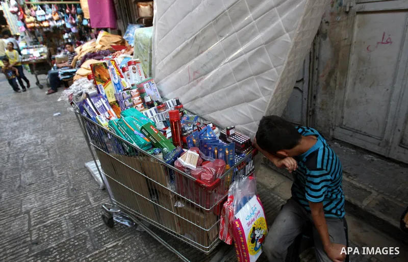 A Palestinian boy sells stuff and food stuff in a wagon at a market in the West Bank city of Nablus, on Aug. 10, 2011. Muslims around the world are observing the holy fasting month of Ramadan where they refrain from eati...