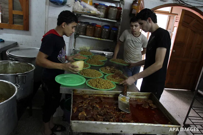 Palestinian bakers prepare rice and meat 'Qedrah" in a traditional stove at Beirut Kitchen in Gaza city on Aug. 10, 2011.during the holy fasting month of Ramadan, when observant Muslims abstain from eating, drinking and...