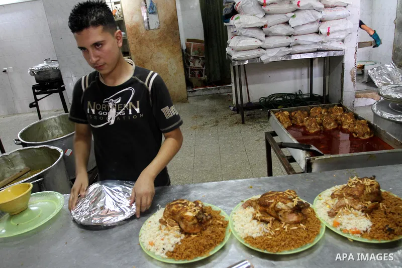 Palestinian bakers prepare chicken and rice 'Qedrah" in a traditional stove at Beirut Kitchen in Gaza city on Aug. 10, 2011, during the holy fasting month of Ramadan, when observant Muslims abstain from eating, drinking...