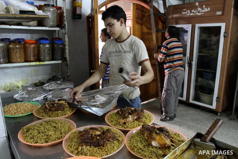 Palestinian bakers prepare chicken and rice 'Qedrah" in a traditional stove at Beirut Kitchen in Gaza city on Aug. 10, 2011, during the holy fasting month of Ramadan, when observant Muslims abstain from eating, drinking...