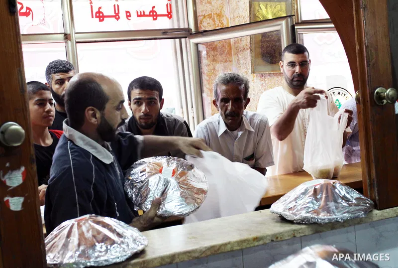Palestinian bakers package rice and meat "Qedrah" in a traditional stove at Beirut Kitchen in Gaza city on Aug. 10, 2011, during the holy fasting month of Ramadan, when observant Muslims abstain from eating, drinking and...