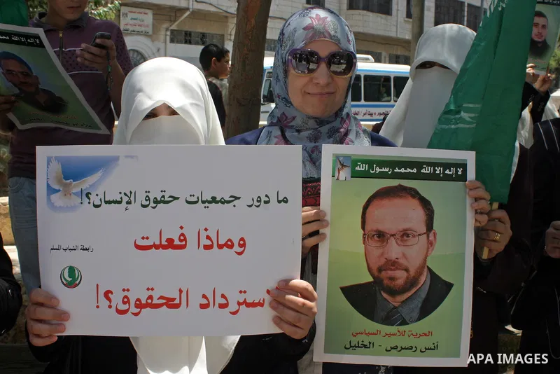 Palestinian Hamas supporters hold pictures of relatives who were arrested and imprisoned for political reasons by Palestinian Authority security forces, during a protest in the West Bank city of Hebron on Aug. 11, 2011....