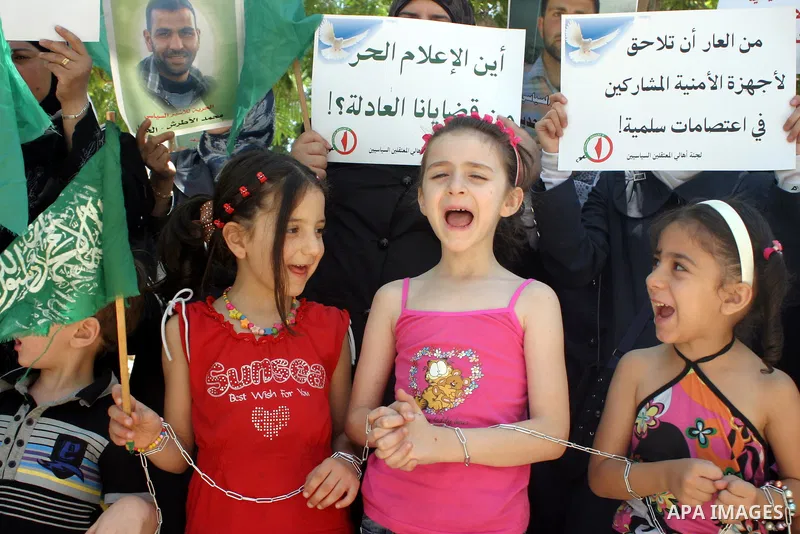 Palestinian Hamas supporters hold pictures of relatives who were arrested and imprisoned for political reasons by Palestinian Authority security forces, during a protest in the West Bank city of Hebron on Aug. 11, 2011....