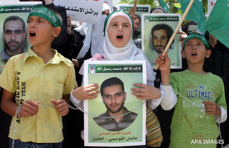 Palestinian Hamas supporters hold pictures of relatives who were arrested and imprisoned for political reasons by Palestinian Authority security forces, during a protest in the West Bank city of Hebron on Aug. 11, 2011....