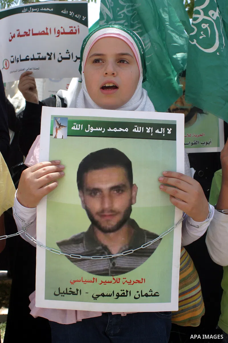 Palestinian Hamas supporters hold pictures of relatives who were arrested and imprisoned for political reasons by Palestinian Authority security forces, during a protest in the West Bank city of Hebron on Aug. 11, 2011....
