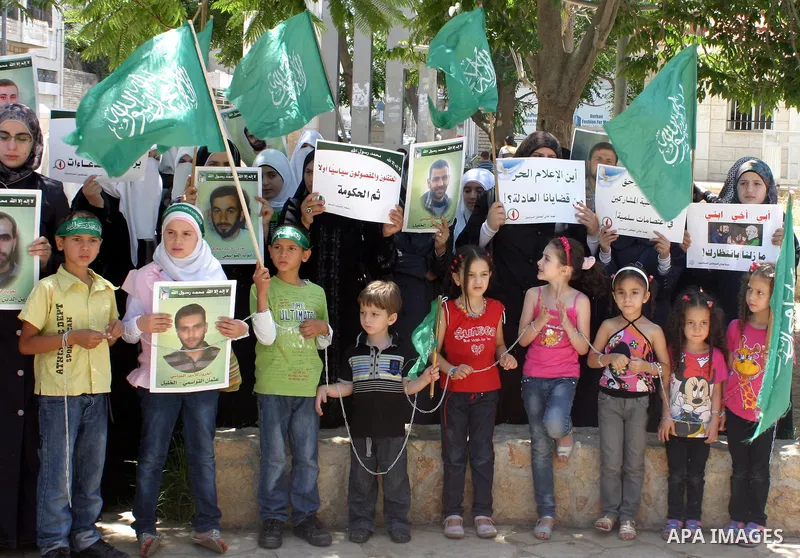 Palestinian Hamas supporters hold pictures of relatives who were arrested and imprisoned for political reasons by Palestinian Authority security forces, during a protest in the West Bank city of Hebron on Aug. 11, 2011....