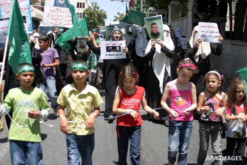 Palestinian Hamas supporters hold pictures of relatives who were arrested and imprisoned for political reasons by Palestinian Authority security forces, during a protest in the West Bank city of Hebron on Aug. 11, 2011....