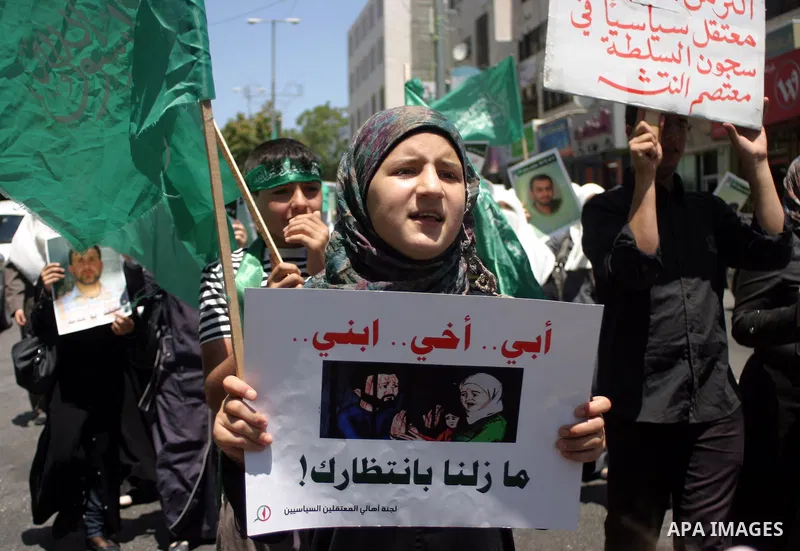 Palestinian Hamas supporters hold pictures of relatives who were arrested and imprisoned for political reasons by Palestinian Authority security forces, during a protest in the West Bank city of Hebron on Aug. 11, 2011....