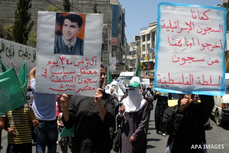 Palestinian Hamas supporters hold pictures of relatives who were arrested and imprisoned for political reasons by Palestinian Authority security forces, during a protest in the West Bank city of Hebron on Aug. 11, 2011....