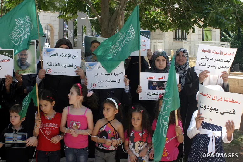 Palestinian Hamas supporters hold pictures of relatives who were arrested and imprisoned for political reasons by Palestinian Authority security forces, during a protest in the West Bank city of Hebron on Aug. 11, 2011....
