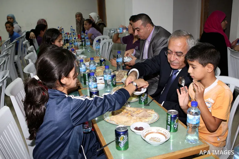 Palestinian Prime Minister, Salam Fayyad during his participation Orphans of the Orphan Care Charitable Society the meal of "Iftar" in the month of Ramadan in the West Bank city of Bethlehem on Aug. 11, 2011. Photo by Mu...