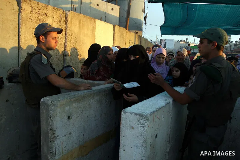 Palestinian women wait in line to pass through the Kalandia checkpoint from the West Bank town of Ramallah to Jerusalem, 12 August 2011, to attend the second Friday prayers in the Muslim holy month of Ramadan at al-Aqsa...