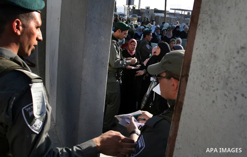 Palestinian women wait in line to pass through the Kalandia checkpoint from the West Bank town of Ramallah to Jerusalem, 12 August 2011, to attend the second Friday prayers in the Muslim holy month of Ramadan at al-Aqsa...