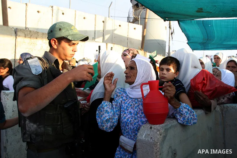Palestinian women wait in line to pass through the Kalandia checkpoint from the West Bank town of Ramallah to Jerusalem, 12 August 2011, to attend the second Friday prayers in the Muslim holy month of Ramadan at al-Aqsa...