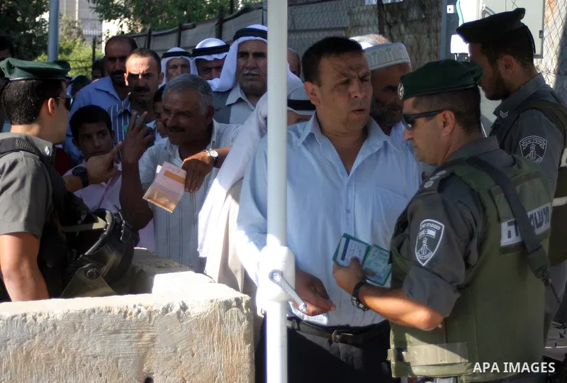 Palestinian Muslims walk through an Israeli checkpoint on the outskirts of the West Bank city of Bethlehem on August 12, 2011 as they wait to cross into Jerusalem to attend the second Friday prayers of the holy fasting m...