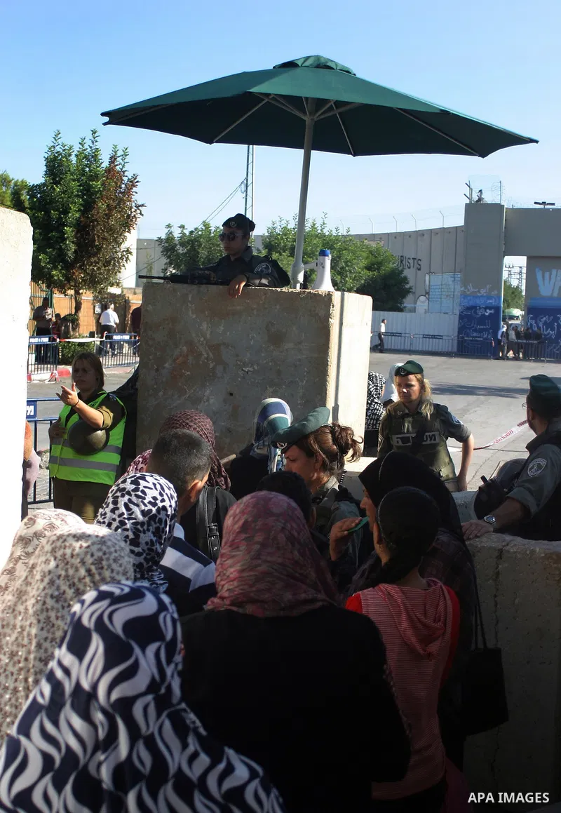 Palestinian Muslims walk through an Israeli checkpoint on the outskirts of the West Bank city of Bethlehem on August 12, 2011 as they wait to cross into Jerusalem to attend the second Friday prayers of the holy fasting m...