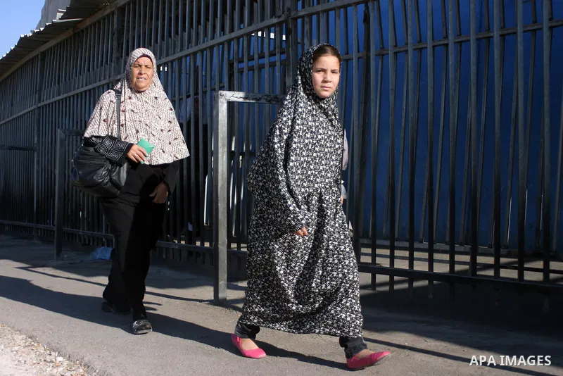 Palestinian Muslims walk through an Israeli checkpoint on the outskirts of the West Bank city of Bethlehem on August 12, 2011 as they wait to cross into Jerusalem to attend the second Friday prayers of the holy fasting m...