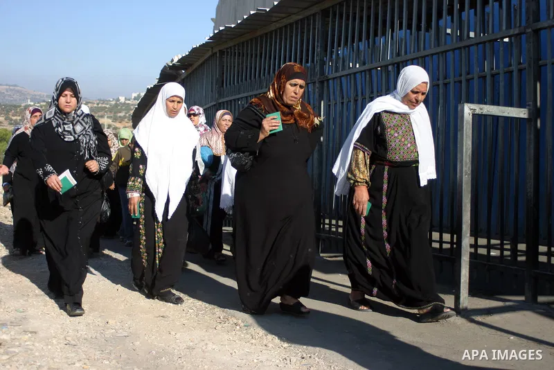 Palestinian Muslims walk through an Israeli checkpoint on the outskirts of the West Bank city of Bethlehem on August 12, 2011 as they wait to cross into Jerusalem to attend the second Friday prayers of the holy fasting m...