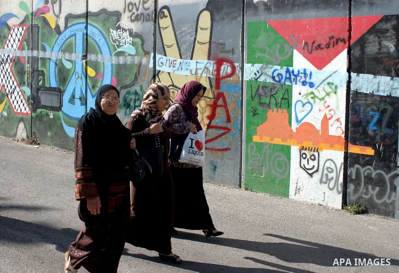 Palestinian Muslims walk through an Israeli checkpoint on the outskirts of the West Bank city of Bethlehem on August 12, 2011 as they wait to cross into Jerusalem to attend the second Friday prayers of the holy fasting m...