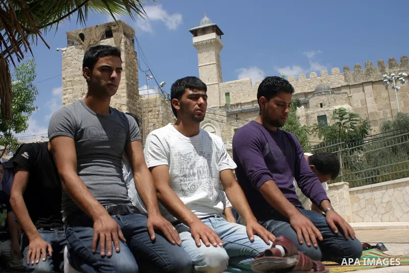 Palestinian attend the second friday prayer of Islam's holy fasting month of Ramadan outside the Ibrahimi mosque, or the Tomb of the Patriarchs, in the divided West Bank city of Hebron on August 12, 2011. Photo by Najeh...