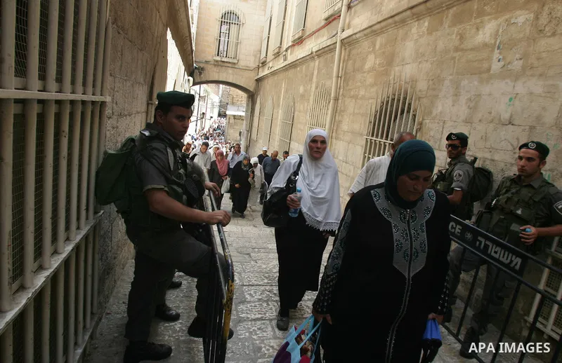 Israeli soldiers watch over Palestinians as they go to the Al Aqsa Mosque in Jerusalem, on the second Friday of the Muslim holy month of Ramadan, Friday Aug. 12, 2011. Muslims around the world are observing the holy fast...