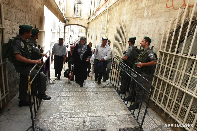 Israeli soldiers watch over Palestinians as they go to the Al Aqsa Mosque in Jerusalem, on the second Friday of the Muslim holy month of Ramadan, Friday Aug. 12, 2011. Muslims around the world are observing the holy fast...