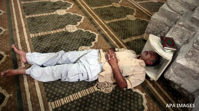 Palestinian man rest as others pray and read the Koran in a mosque during the holy month of Ramadan in Central of Gaza City on 12 August 2011. Muslims around the world are observing the holy fasting month of Ramadan in w...