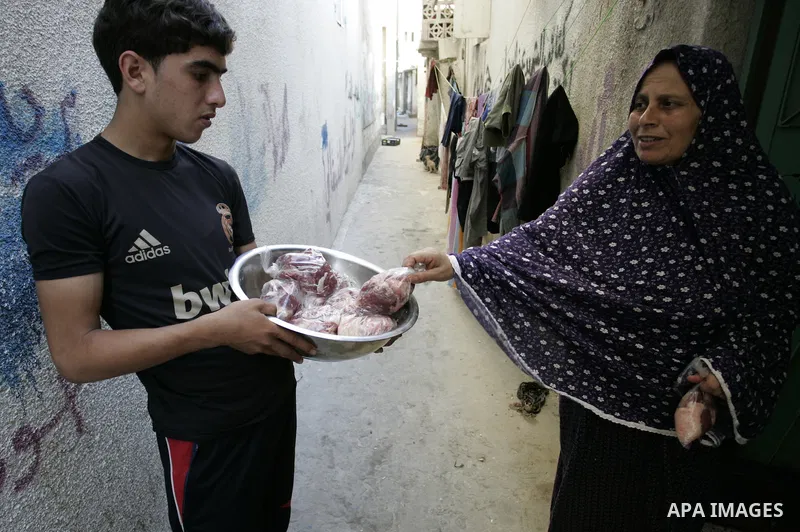 A Palestinian boy participates in the distribution of meat on the homes of the poor and needy on the thirteenth day at the occasion of the holy fasting month of Ramadan in Rafah, southern Gaza Strip on Aug. 13, 2011. whe...